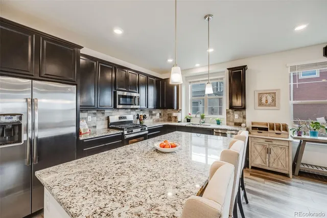 a large kitchen with a table chairs refrigerator and microwave