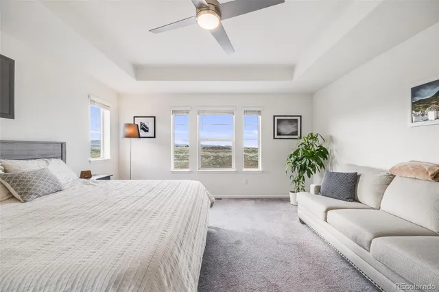 a spacious bedroom with a large bed couch and a window