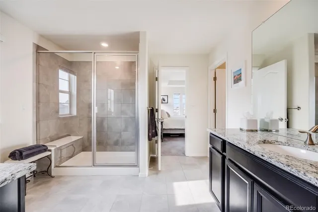a bathroom with a granite countertop sink mirror and shower