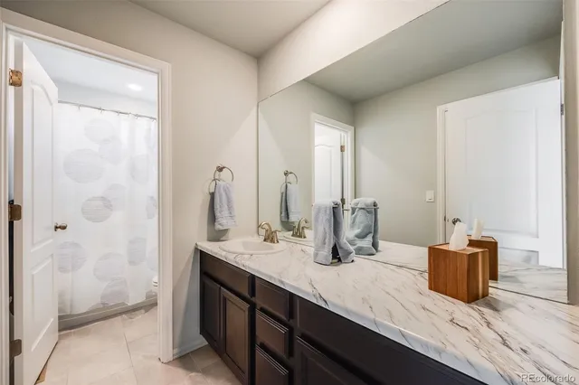 a bathroom with a granite countertop sink and a mirror