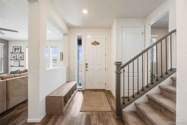 a view of a hallway with wooden floor and staircase