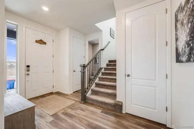 a view of a hallway with wooden floor and entryway