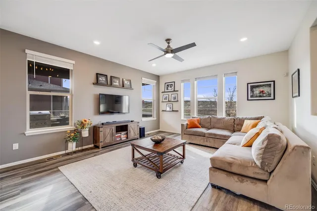 a living room with furniture ceiling fan and a window