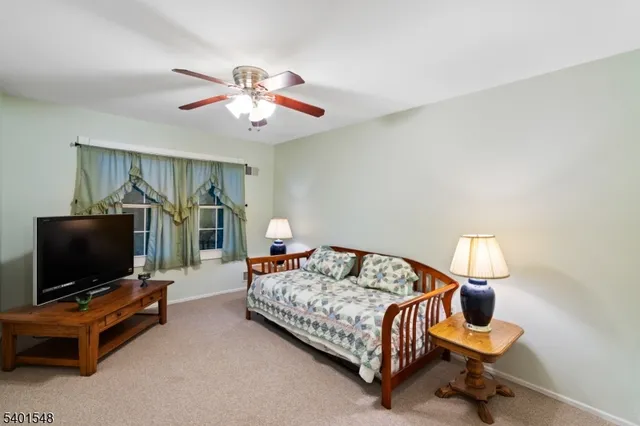 a bedroom with bed and a flat tv screen on dresser