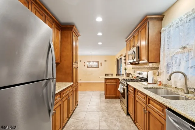 a kitchen with stainless steel appliances granite countertop a sink and a refrigerator