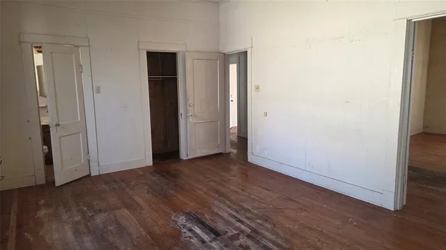 an empty room with wooden floor and closet