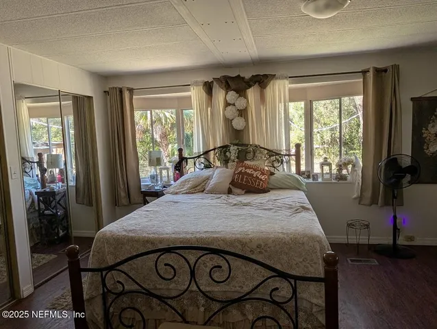 a bedroom with a bed and large windows