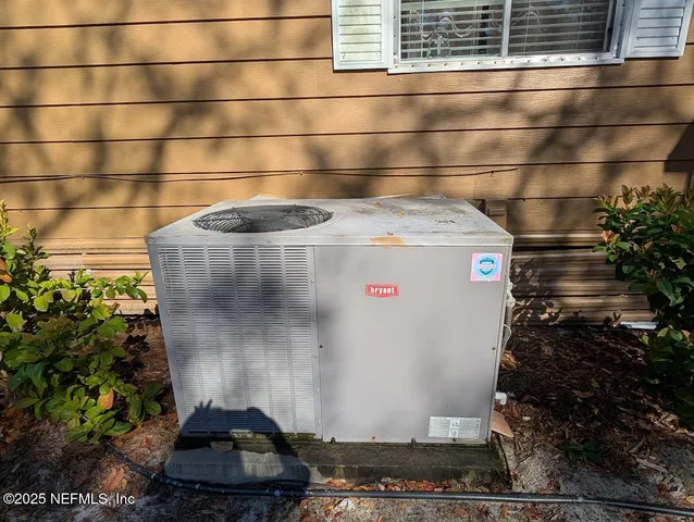 a backyard of a house with large trees and brick wall