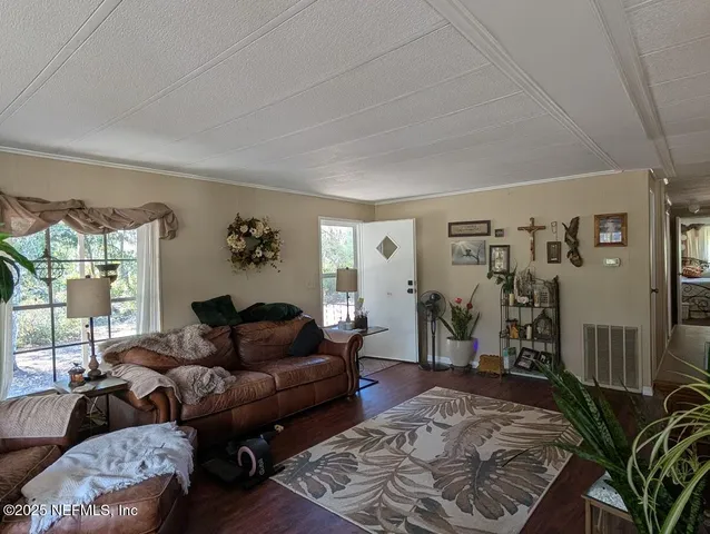 a living room with furniture a window and a wooden floor