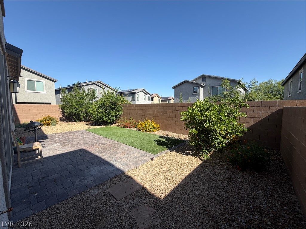 3228 Azalea Ridge Court Henderson, NV 89052 - Photo 24 of 28 A private outdoor space with a paved patio, lush green lawn, and decorative gravel for easy maintenance.