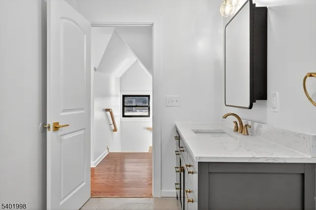 a bathroom with a double vanity sink toilet mirror and bathtub