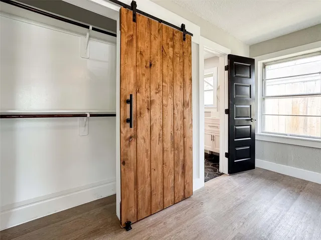 a view of walk in closet with wooden floor and entryway