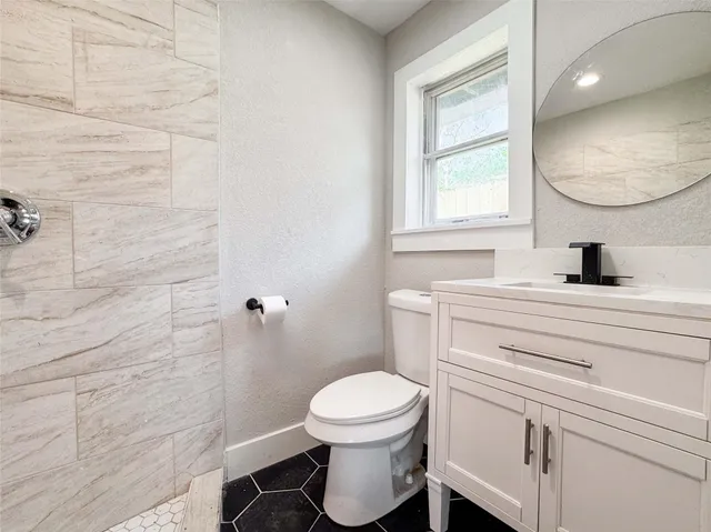 a bathroom with a toilet a sink and mirror