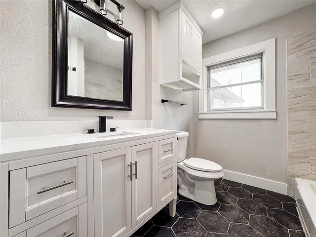a bathroom with a toilet sink and mirror