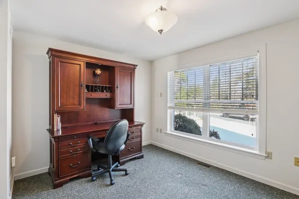 a view of a workspace with furniture and a window