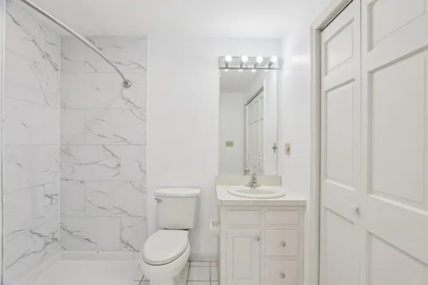 a bathroom with a granite countertop sink a toilet and a mirror