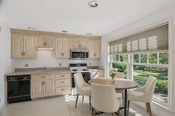 a kitchen with a stove a sink a dining table and chairs