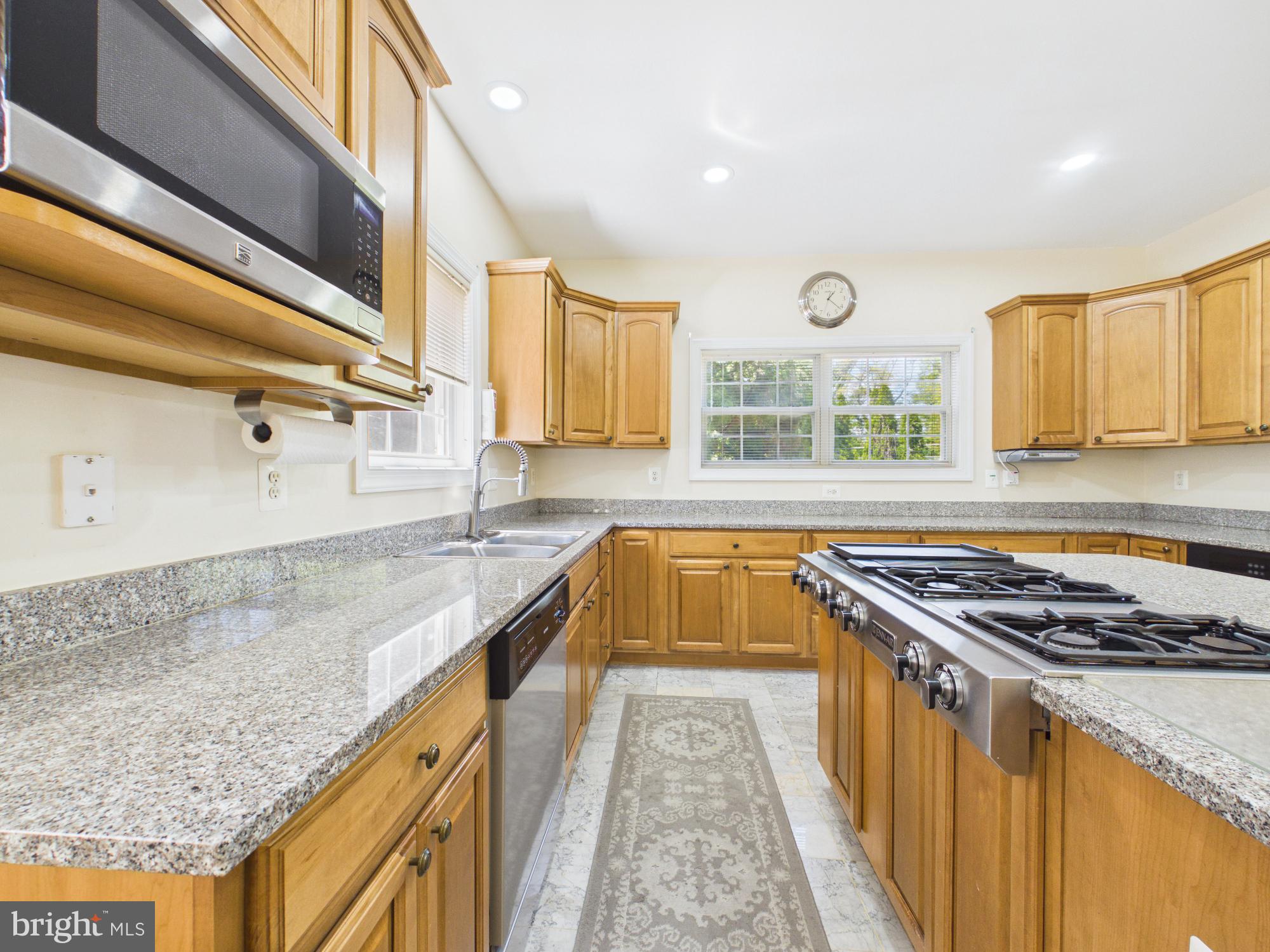 7801 Ridgewood Drive Annandale, VA 22003 - Photo 17 of 72 a kitchen with stainless steel appliances granite countertop a sink a stove and a wooden floors