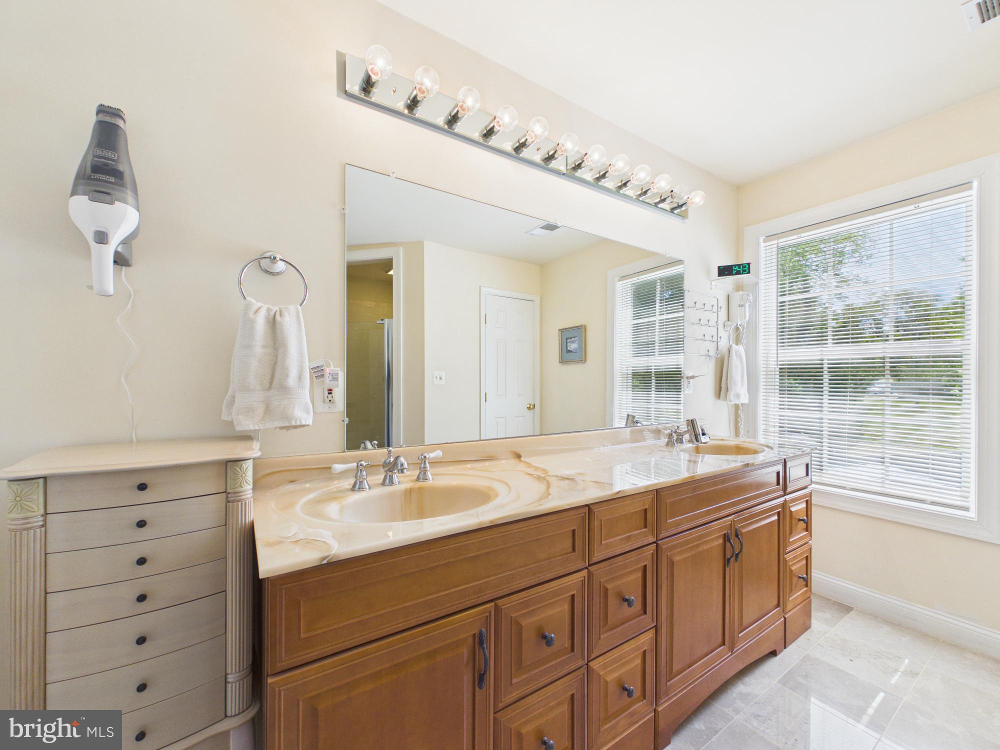 7801 Ridgewood Drive Annandale, VA 22003 - Photo 36 of 72 a en suite bathroom with a double vanity sink and a mirror
