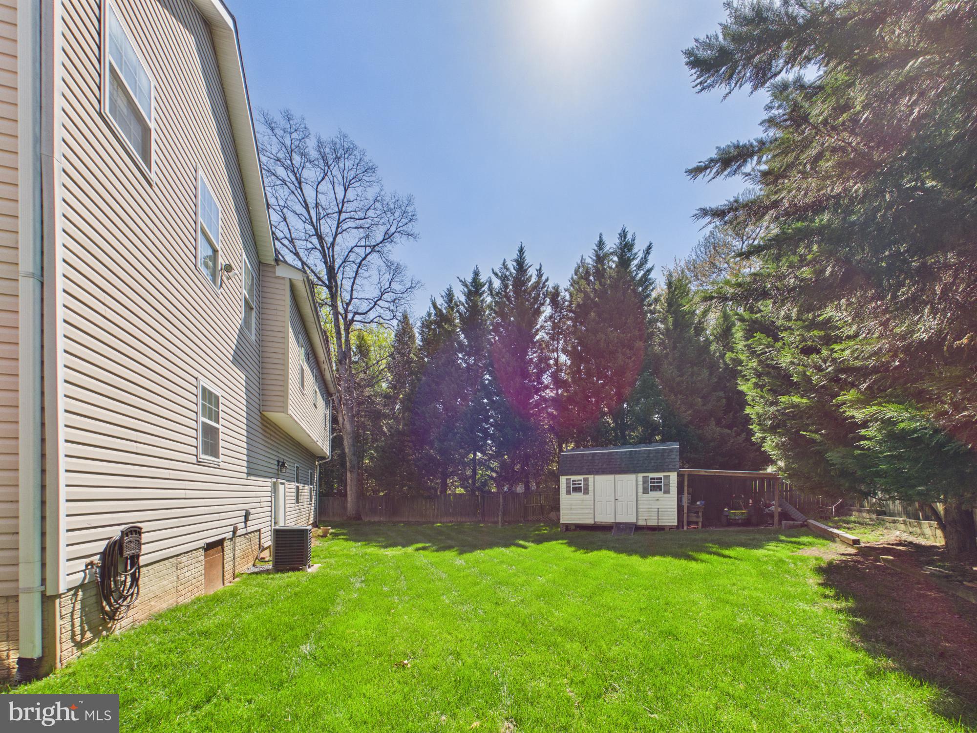 7801 Ridgewood Drive Annandale, VA 22003 - Photo 65 of 72 a backyard of a house with table and chairs and a large tree