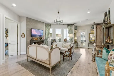 a living room with furniture a chandelier and a fireplace