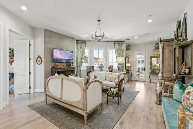 a living room with furniture a chandelier and a fireplace