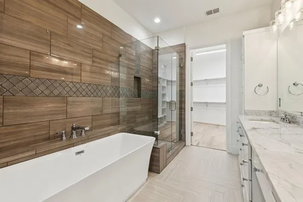 a bathroom with a granite countertop sink a mirror and shower