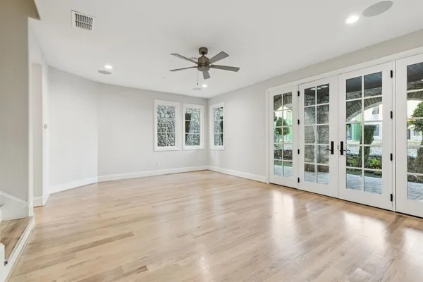 a view of an empty room with a window and wooden floor