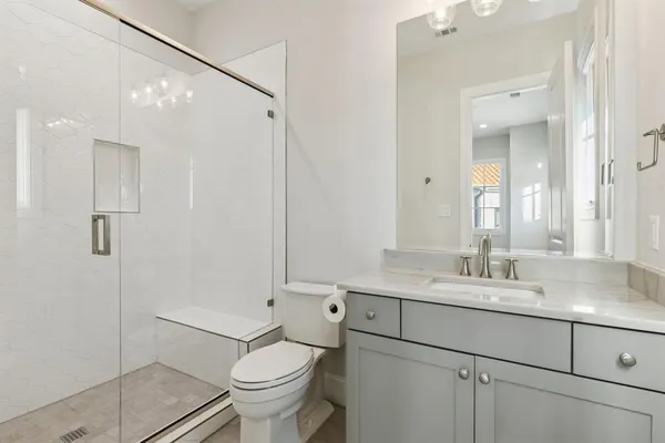 a bathroom with a sink toilet vanity and shower