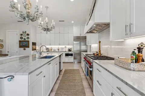 a kitchen with kitchen island granite countertop a sink a counter space and cabinets