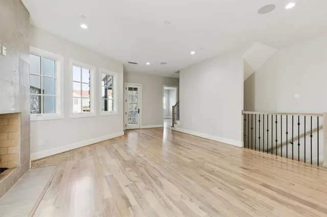 a large kitchen with granite countertop a stove a refrigerator a sink dishwasher a dining table and chairs with wooden floor