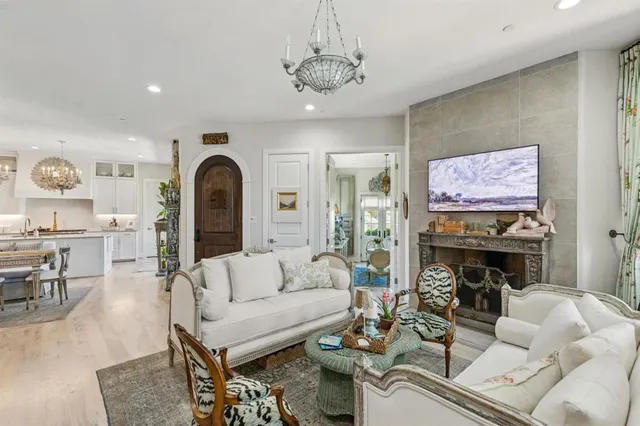 a living room with furniture a fireplace and a chandelier