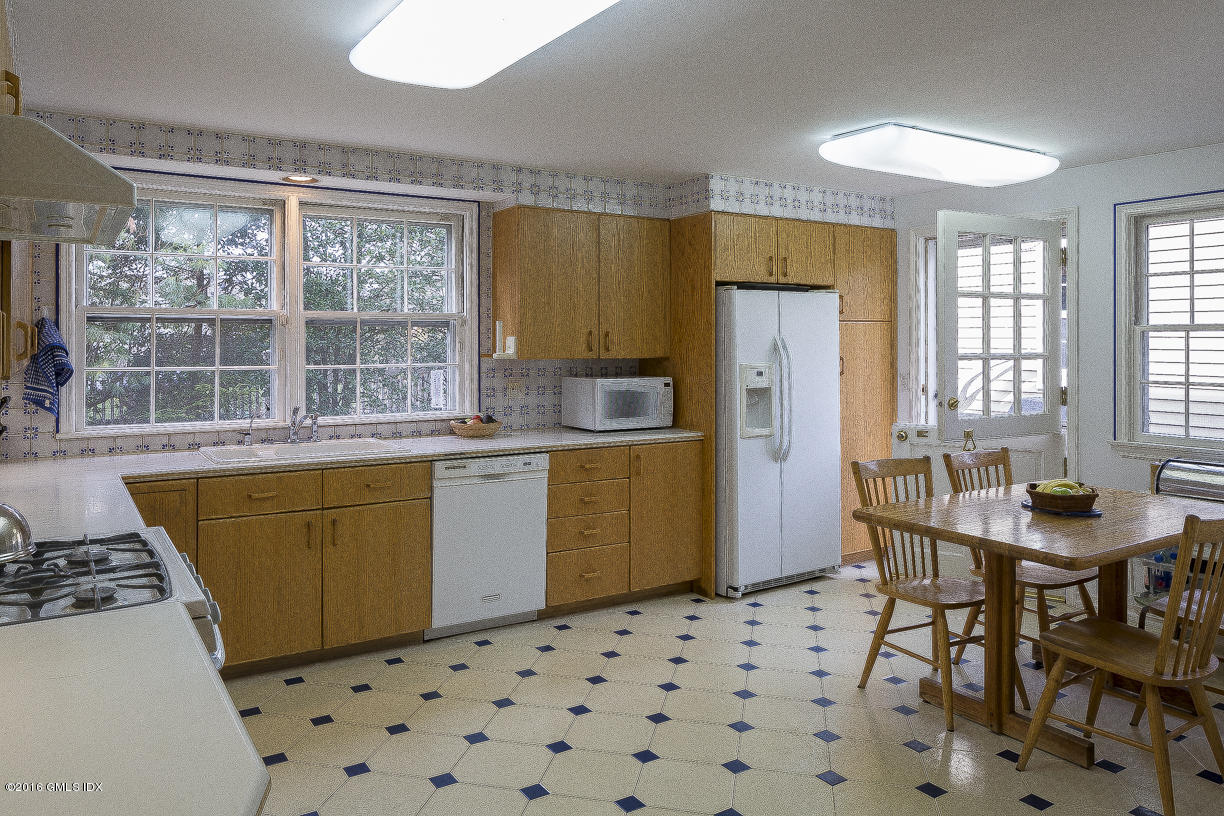 2 Boxwood Lane Greenwich, CT 06830 - Photo 13 of 23 a kitchen with a sink a stove a refrigerator a dining table and chairs