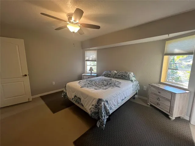 a bedroom with a bed and a ceiling fan in it