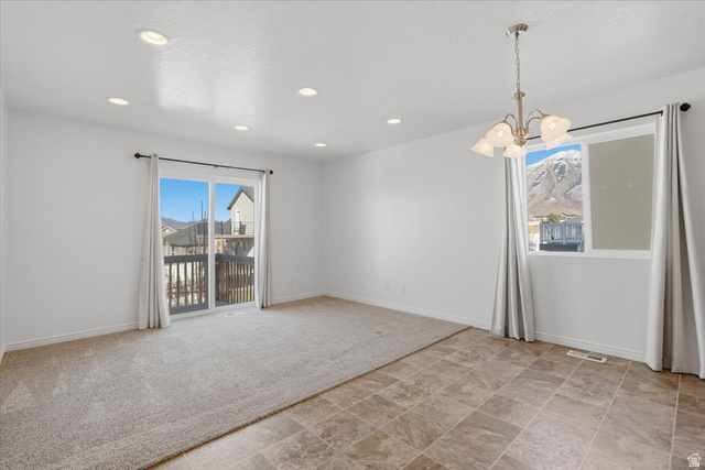 1218 Moonlight Drive Elk Ridge, UT 84651 - Photo 5 of 44 Unfurnished room with suspended lighting, stone finish flooring, healthy amount of natural light, and light carpet