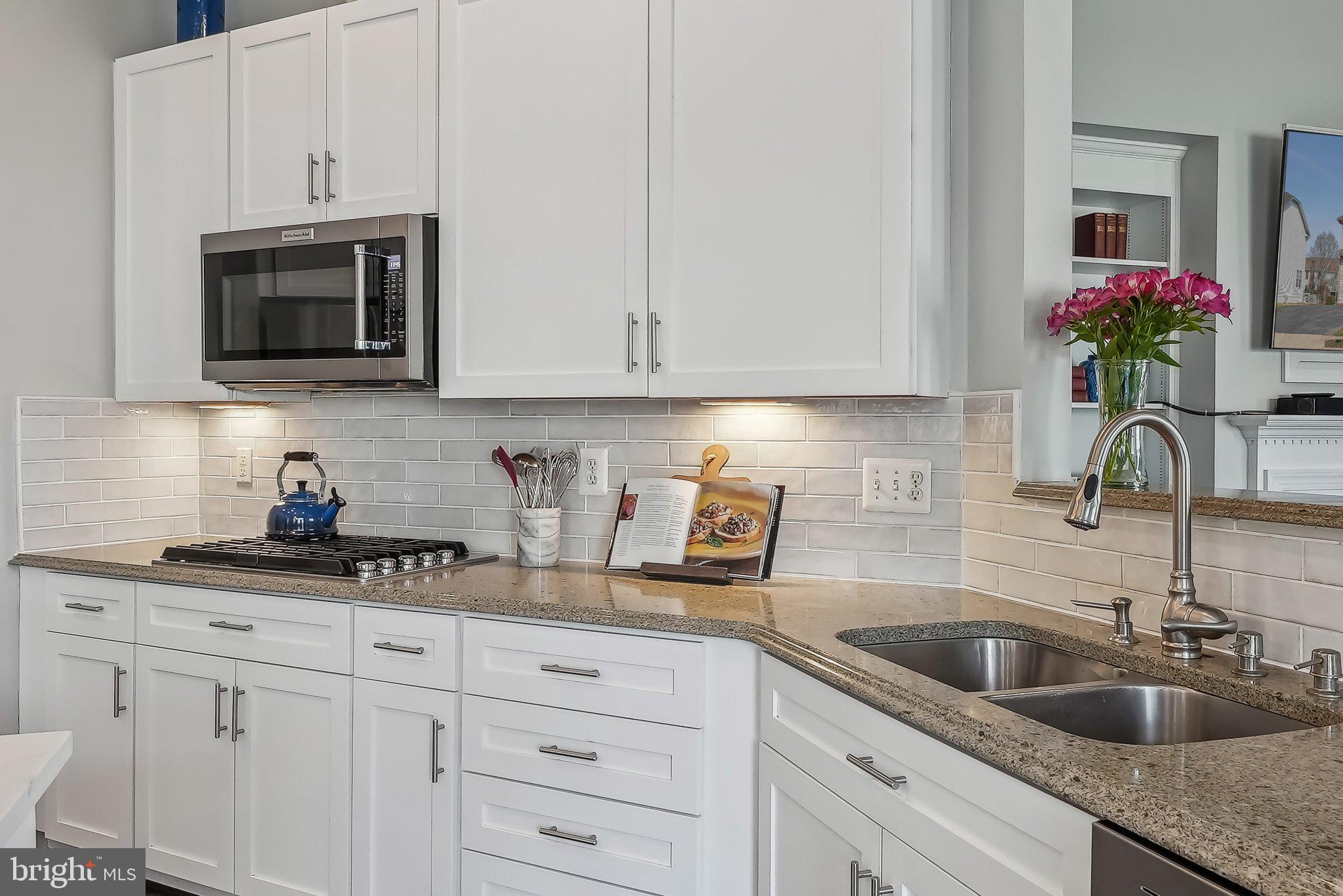 9061 Roaring Spring Loop Bristow, VA 20136 - Photo 12 of 55 a kitchen with stainless steel appliances granite countertop white cabinets a sink and dishwasher