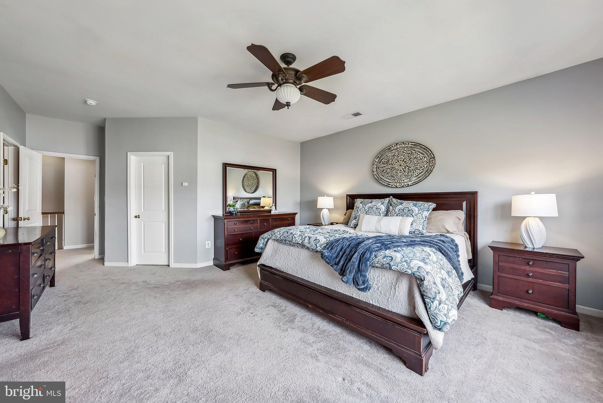9061 Roaring Spring Loop Bristow, VA 20136 - Photo 32 of 55 a bedroom with a bed and a ceiling fan