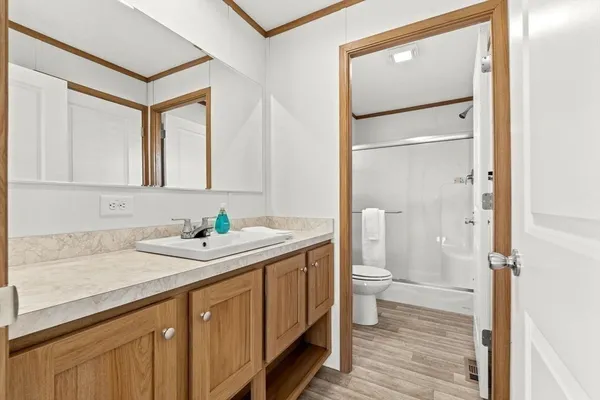 a bathroom with a granite countertop sink mirror and a toilet