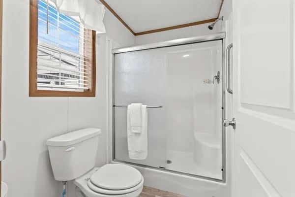 a white toilet next to a bathroom