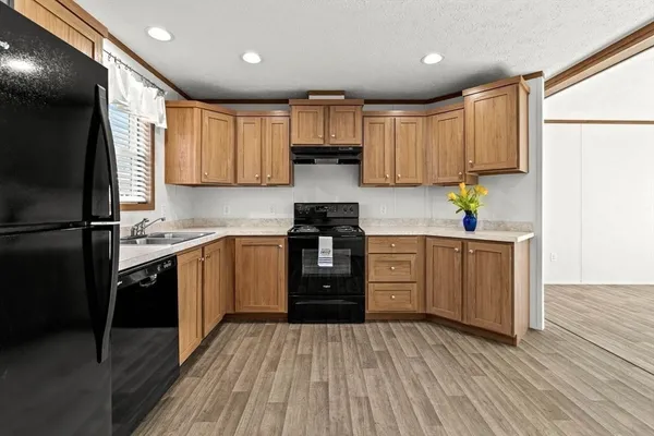 a kitchen with granite countertop a refrigerator stove top oven and sink