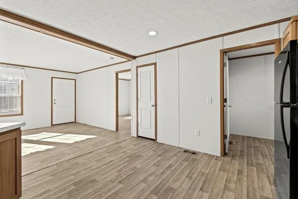 a view of empty room with wooden floor and cabinet