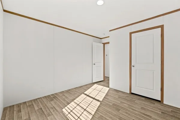 a view of a room with wooden floor and white walls