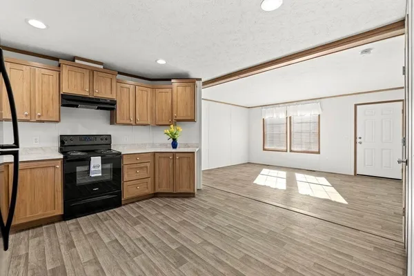 a kitchen with granite countertop a stove a sink and a refrigerator