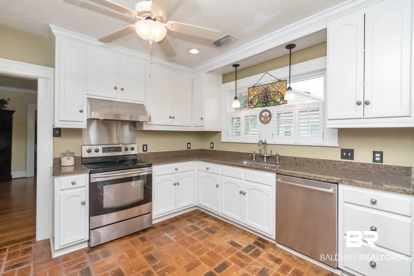 117 South Fulton Street Mobile, AL 36606 - Photo 7 of 34 Kitchen featuring pendant lighting, sink, ceiling fan, appliances with stainless steel finishes, and white cabinets