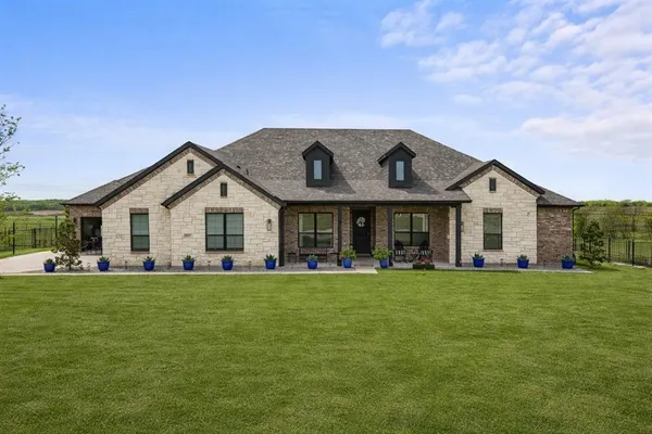 a front view of a house with a garden and yard