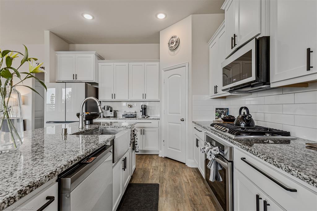 6513 Earley Way Forney, TX 75126 - Photo 12 of 36 a kitchen with stainless steel appliances granite countertop a sink stove and refrigerator