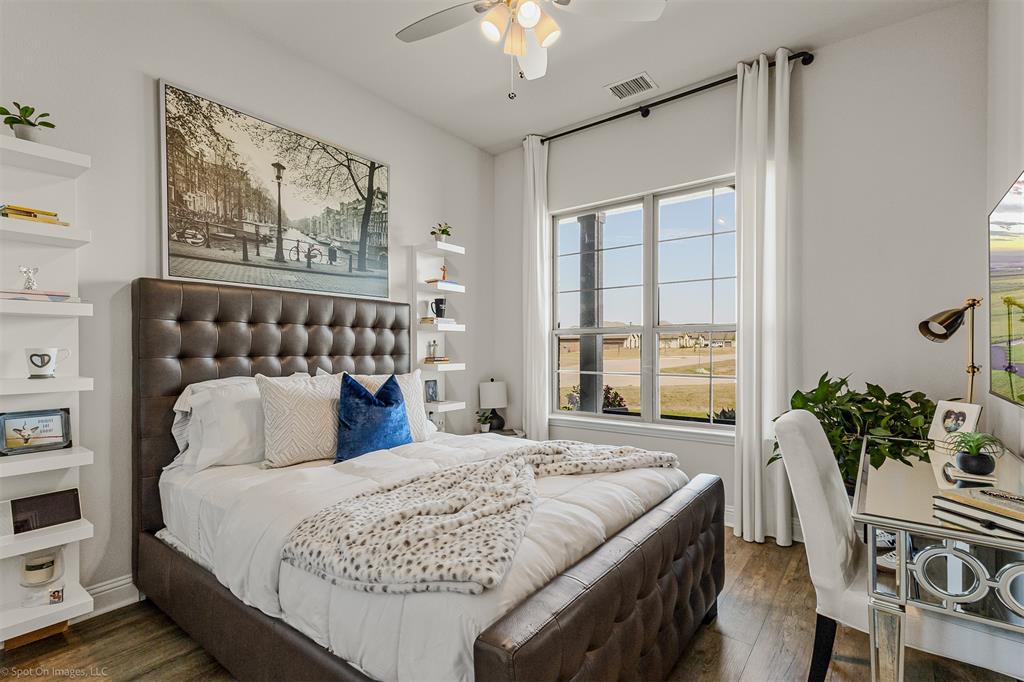 6513 Earley Way Forney, TX 75126 - Photo 27 of 36 a bedroom with a large bed and a chandelier