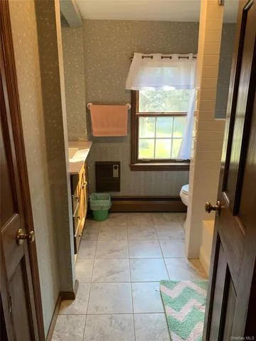 a bathroom with a granite countertop sink a toilet and a mirror