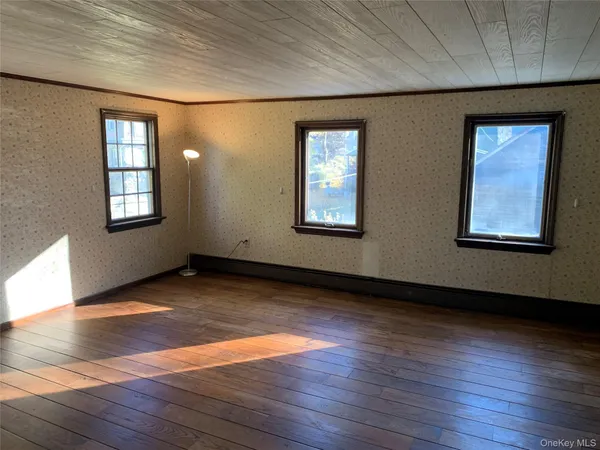 a view of a hallway with wooden floor and a window
