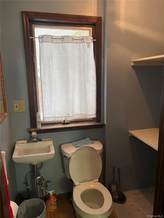 a bathroom with a toilet a sink and a mirror